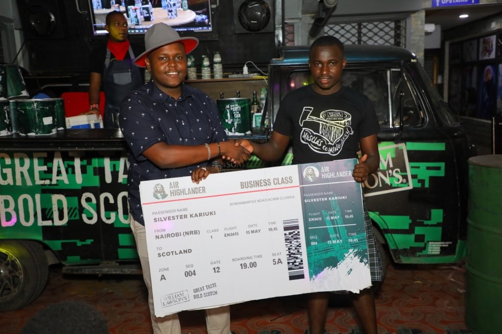 Mr. Silvester Kariuki receiving his flight ticket to Scotland from James Mbone