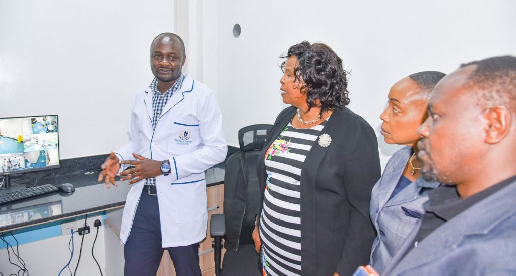 KUTRRH Medical Physicist Peter Loreh (left) updates Chairperson Prof Olive Mugenda as Board Members Kavi Mwendwa and Nzumbi Mulatya look during the first CyberKnife treatment.