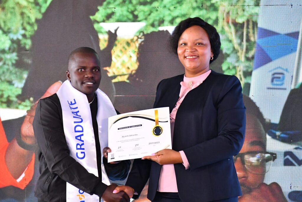 Family Bank CEO Designate Nancy Njau awards a certificate to Wycklife Odhiambo during the graduation ceremony of 250 youth from a Software Development Training programme, a Sh10 million co-investment between the The Family Group Foundation and Adanian Labs.